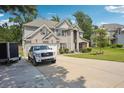 Beautiful two-story home with a two-car garage and a spacious driveway surrounded by lush greenery at 3796 Village Crossing Ln, Ellenwood, GA 30294