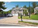 Lovely two-story home featuring a well-kept lawn, two-car garage, and a spacious driveway at 3796 Village Crossing Ln, Ellenwood, GA 30294