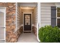 Inviting entryway with stylish front door, stone accents, and neutral siding, creating a warm welcome at 263 Jefferson Ave, Canton, GA 30114