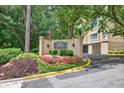 Sign at The Terraces-At Peachtree community entrance features lush greenery and a manicured lawn at 1 Biscayne Nw Dr # 112, Atlanta, GA 30309