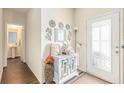 Bright entryway featuring a decorated cabinet, white door with decorative glass, and a view into the half bathroom at 3350 Clawing Hawk Way, Douglasville, GA 30135