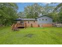 Backyard view of the two-story home with a deck, well-maintained lawn, brick accents, and an RV at 1031 Washington Ave, Woodstock, GA 30188