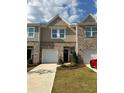 Attractive townhomes showcasing brick and siding exteriors, with green lawns and attached garages at 544 Magnolia Circle, Palmetto, GA 30268