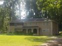 Large two-story home with a covered entry and lush greenery in a serene, wooded setting at 110 Chippewa Ct, Riverdale, GA 30296