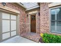 Close-up of the brick facade, arched entryway, and dark wood front door, adding architectural interest to this home at 1549 Lake Holcomb Ln, Marietta, GA 30062