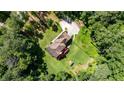 Expansive lot and lush greenery surround this home with a brown roof and concrete driveway at 6945 John Rivers Rd, Fairburn, GA 30213