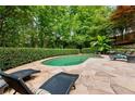 Serene backyard pool area with lounge chairs, manicured hedges and a lush green landscape at 910 Kings Arms Way, Johns Creek, GA 30022
