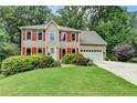 Attractive two-story home featuring well-kept lawn, vibrant red shutters, and a two-car garage at 1019 Wolf Springs Ct, Lawrenceville, GA 30043