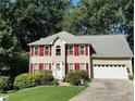 Charming two-story home featuring a well-manicured lawn, bright red shutters, and an attached two-car garage at 1019 Wolf Springs Ct, Lawrenceville, GA 30043