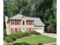 Traditional two-story home featuring red shutters, a green lawn, and an attached two-car garage at 1019 Wolf Springs Ct, Lawrenceville, GA 30043