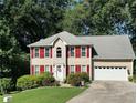 Beautiful two-story home with red shutters, a lush lawn, and an attached two-car garage at 1019 Wolf Springs Ct, Lawrenceville, GA 30043
