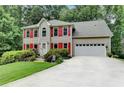 Beautiful two-story home with a lush front lawn, red shutters, and a convenient attached garage at 1019 Wolf Springs Ct, Lawrenceville, GA 30043