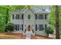 Charming two-story home featuring a gray brick facade, black shutters, and a manicured front yard at 3267 Standing Peachtree Trl, Kennesaw, GA 30152