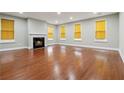 Spacious living room with hardwood floors, fireplace, and abundant natural light from large windows at 5933 Brookside Oak Cir, Norcross, GA 30093