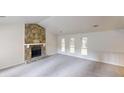 Bright living room featuring a vaulted ceiling and stone fireplace, offering a cozy and inviting atmosphere at 1169 Oaks Pl, Stone Mountain, GA 30083