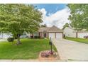 Beautiful brick home with a manicured lawn, flowers, and a two-car garage at 2895 Dominion Walk Ln, Snellville, GA 30078