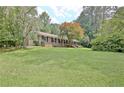 Beautiful brick home with a large front yard and lush trees, offering a serene setting at 501 Bridlepath Ln, Peachtree City, GA 30269