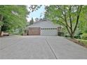 Spacious two-car garage with brick facade and large driveway for easy access and parking at 501 Bridlepath Ln, Peachtree City, GA 30269