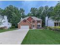 Traditional two-story brick home with a well-manicured lawn, mature trees and an attached two-car garage at 4271 Edgewater Drive Northwest Nw Dr, Kennesaw, GA 30144
