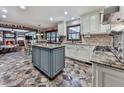 Bright kitchen featuring an island, stone tile floors, stainless steel appliances, and stone countertops at 4271 Edgewater Drive Northwest Nw Dr, Kennesaw, GA 30144