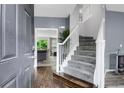 Inviting foyer with hardwood floors, gray walls, and a staircase with white banister at 8690 Cedar Creek Rdg, Riverdale, GA 30274