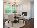 Cozy dining room boasts a round table, elegant chandelier, large window, and white brick fireplace at 1393 Sagewood Cir, Stone Mountain, GA 30083