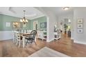 Open dining room with hardwood floors, a chandelier, and green walls, creating an inviting atmosphere at 2045 Barrett Downs Dr, Cumming, GA 30040