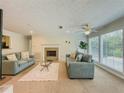 Bright living room with two sofas, a fireplace, and large windows showcasing natural light at 907 Olde Mill Ln, Norcross, GA 30093