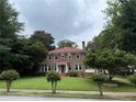 Charming two-story red brick home with lush green lawn and mature trees, enhancing curb appeal at 1098 Oakdale Ne Rd, Atlanta, GA 30307