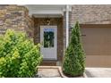 Close-up of the front entryway with a decorative wreath on the door and manicured shrubs at 280 Woods Creek Drive, Suwanee, GA 30024