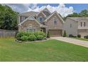 Charming two-story home featuring a manicured lawn, brick and stone accents, and a two-car garage at 280 Woods Creek Drive, Suwanee, GA 30024