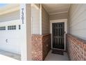 Close-up of a home's entryway featuring a stylish black door and brick accents at 7301 Cranleigh St, Covington, GA 30014