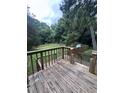 Wooden deck overlooking a fenced backyard with mature trees and shade at 2169 Tiffany Ln, Lithonia, GA 30058