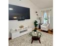 Modern living room with a large TV, contemporary furniture, and a plush rug for comfort at 507 Legacy Park Ln, Powder Springs, GA 30127
