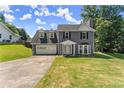 Charming two-story home featuring a two-car garage, manicured lawn, and classic architectural details at 625 Hickory Nobb, Sugar Hill, GA 30518