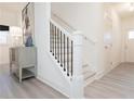 Bright foyer featuring a staircase with black iron balusters and light gray wood-look flooring at 2453 Honey Way, Conyers, GA 30013