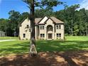 Classic brick home nestled among trees, with a sprawling front lawn and inviting curb appeal at 2571 Se Ebenezer Rd, Conyers, GA 30094