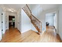 Bright foyer featuring hardwood floors, a staircase with wood banister, and white trim at 5826 Andover Way, Tucker, GA 30084