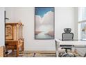Bright office with modern desk, ornate cabinet and rug, and a large painting with a river scene at 1762 Beckham Ne Pl, Atlanta, GA 30324