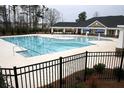 Large community pool with lap lanes and mushroom fountains and nearby clubhouse at 4865 Fourth Rail Ln, Cumming, GA 30040