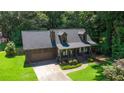 Traditional home featuring an attached garage, inviting front porch and mature landscaping at 1066 Sea Oats Sw Way, Lilburn, GA 30047