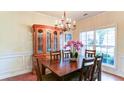 Sunlit dining room featuring a classic china cabinet and charming chandelier at 1810 Stardust Trl, Cumming, GA 30040