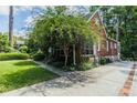 Brick home featuring a driveway with brick trim, stone accents, and mature trees at 401 Emory Ne Dr, Atlanta, GA 30307