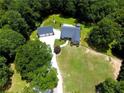 Expansive aerial view showcasing a wooded property with detached garage and circular drive at 5300 Haynes Creek Dr, Loganville, GA 30052
