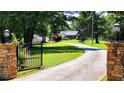 Inviting entrance with brick columns, iron gate and long driveway leading to the home at 5300 Haynes Creek Dr, Loganville, GA 30052