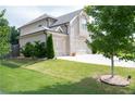Well-maintained home exterior features a three-car garage, lush green lawn, and mature landscaping at 3739 In Bloom Way, Auburn, GA 30011