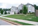 Charming home with lush green lawn and mature trees offering great curb appeal on a tree lined street at 3739 In Bloom Way, Auburn, GA 30011