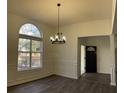 Bright dining room featuring a large arched window, elegant chandelier, and modern flooring at 3920 Knotts Pass Rd, Snellville, GA 30039