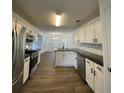 Modern kitchen with stainless steel appliances, white cabinetry, granite countertops, and an island at 3920 Knotts Pass Rd, Snellville, GA 30039
