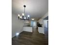 Bright kitchen featuring white cabinets, granite countertops, modern lighting, and wood-look flooring at 3920 Knotts Pass Rd, Snellville, GA 30039
